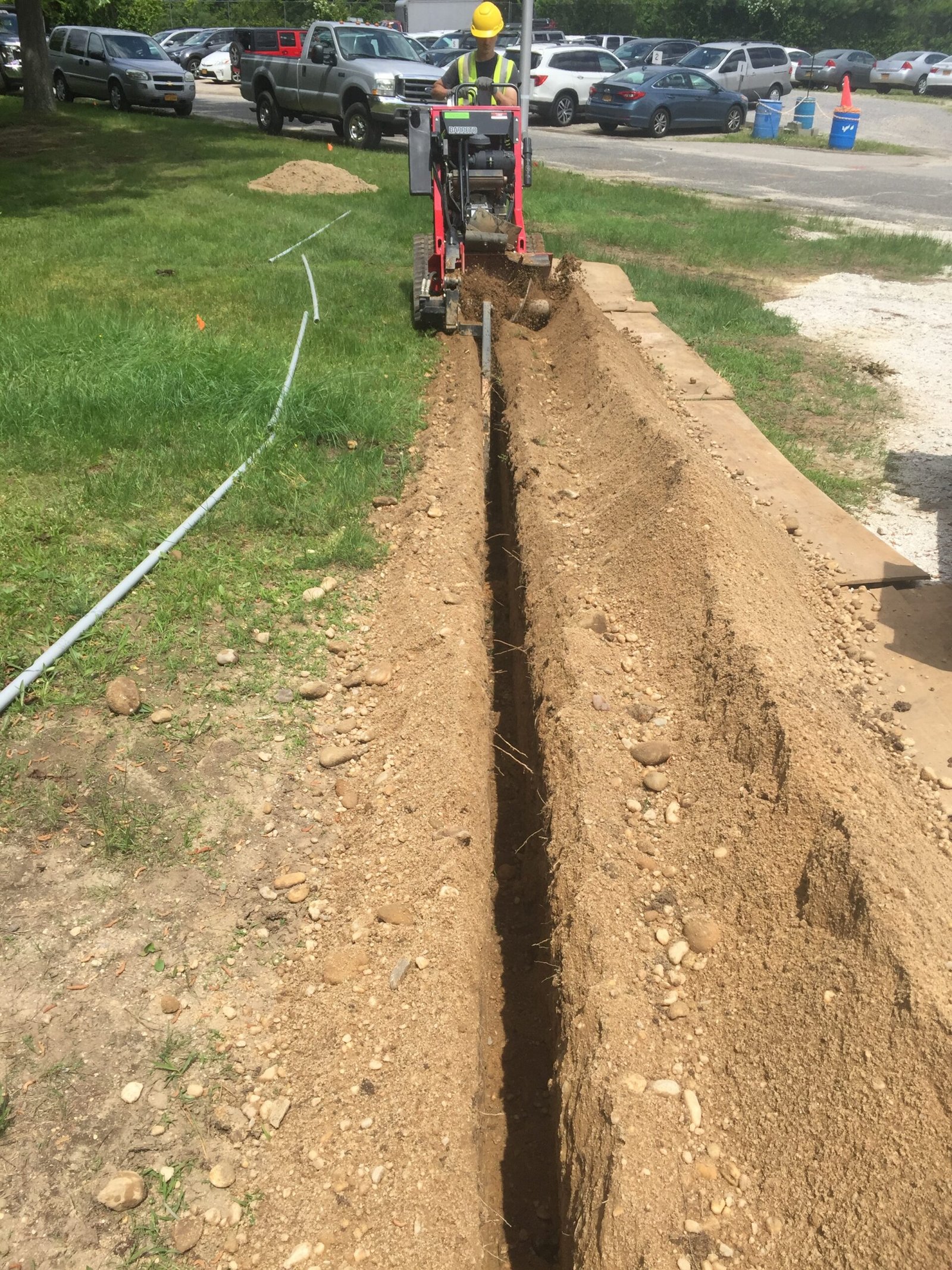 Worker digging trench with machine
